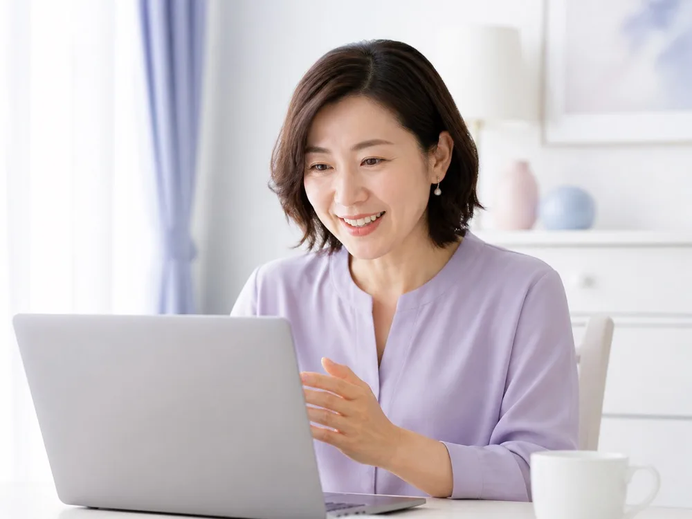 オンライン通話をしながら笑顔で話している女性